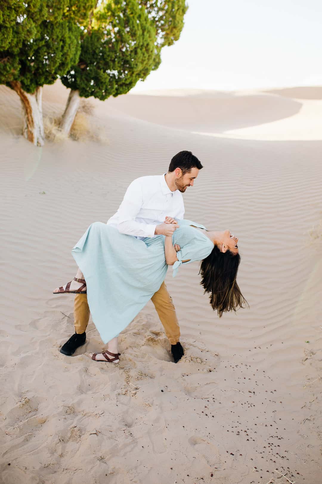 Flowing blue dress in the sand engagements