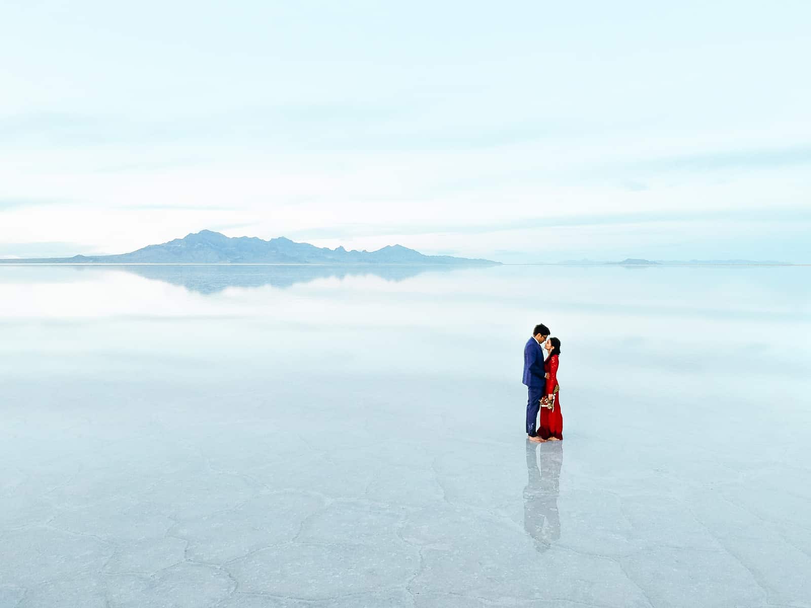 drone photography, Bonneville Salt Flats Engagement Photos, Utah engagement session, engagement photography, red dress, clouds, water reflection, destination wedding