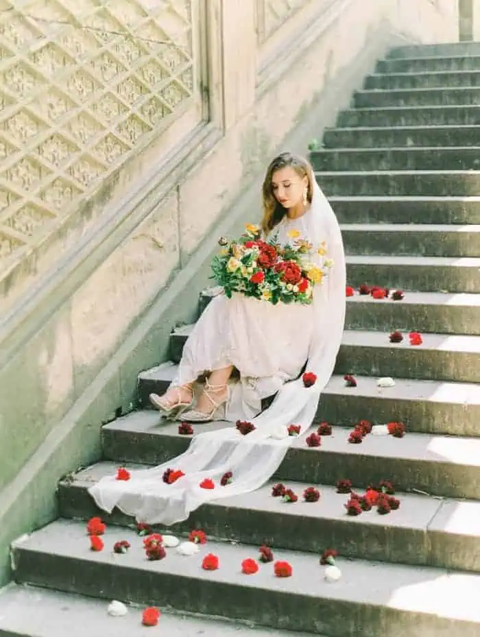 red rose pedals on white wedding dress