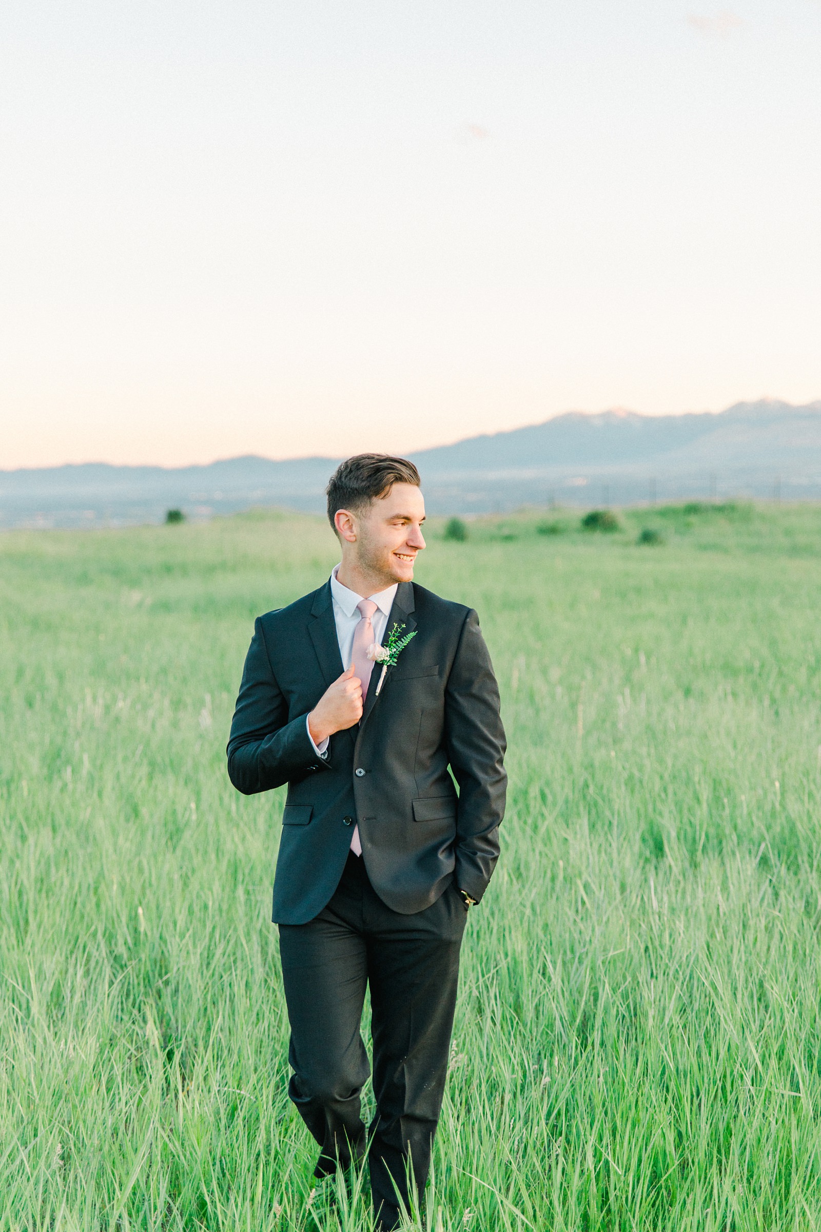 Salt Lake City Utah Bridal Wedding Photography, Tunnel Springs Park, groom in dark gray suit and pink tie, open green field