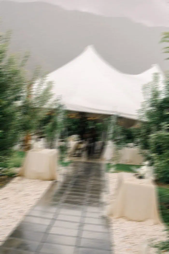 Outdoor event tent setup with greenery.