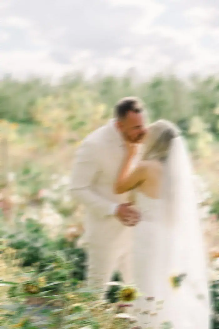 Wedding couple embracing outdoors in a soft-focus shot.