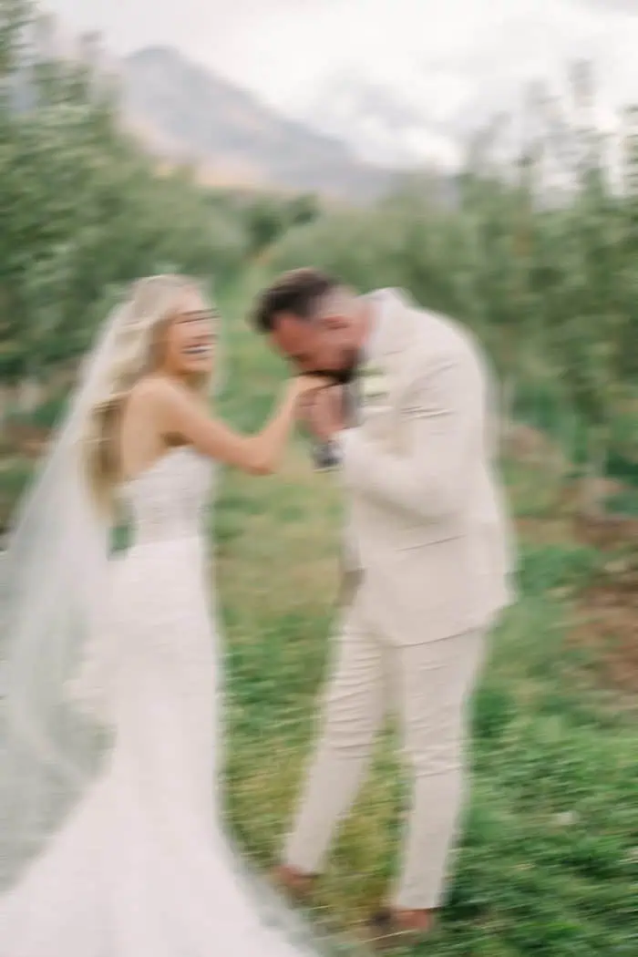 Wedding couple holding hands and smiling outdoors.