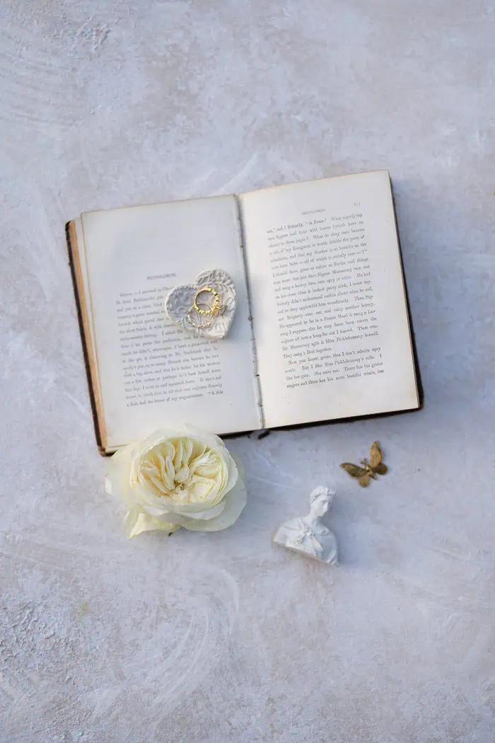 Elegant open book with jewelry and flowers.