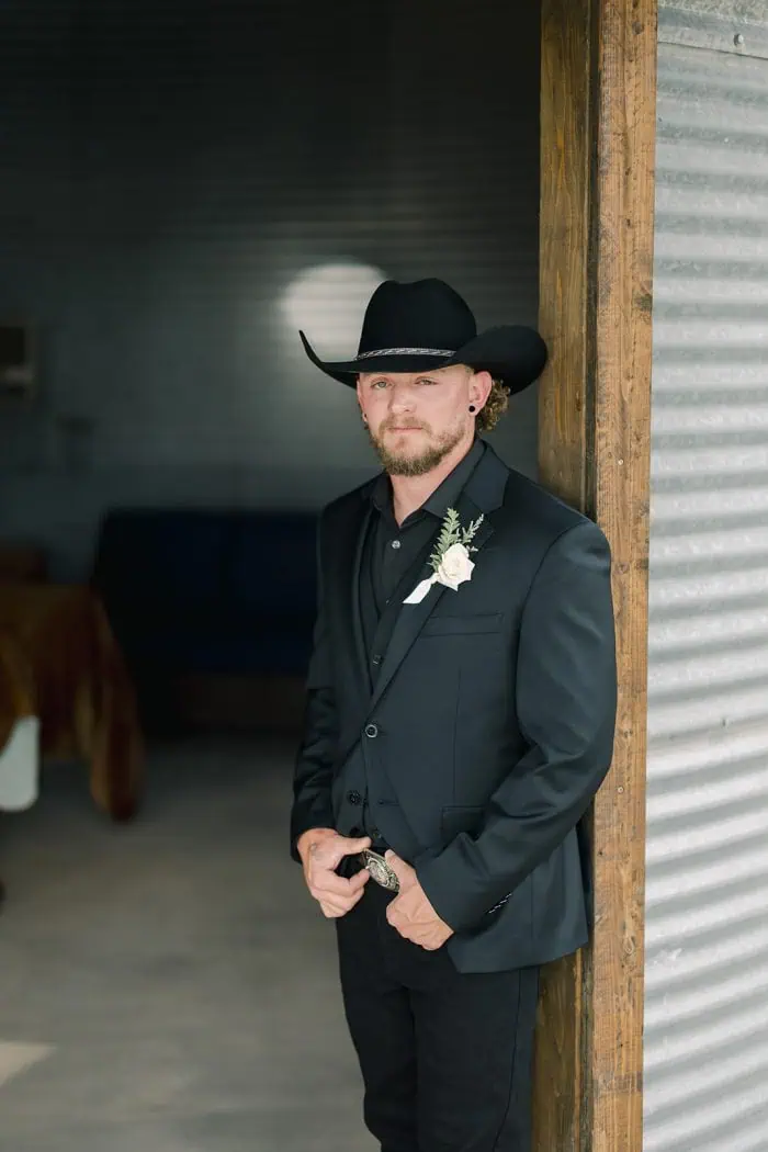 Portrait of Branson Maxwell in cowboy hat and suit at a rustic venue.