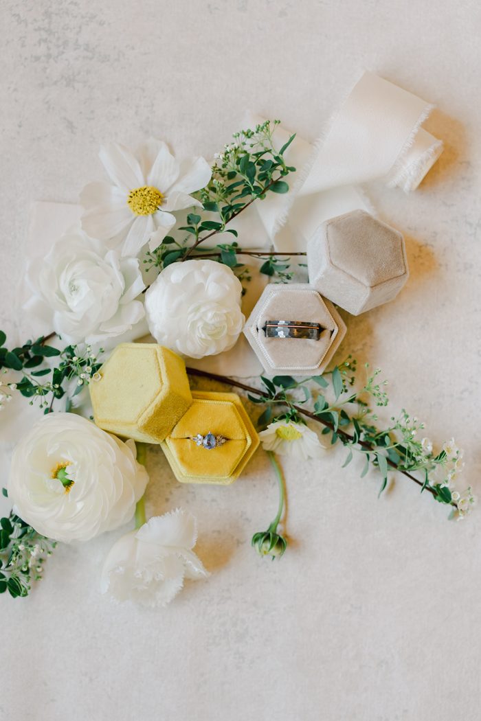 Jewelry presentation featuring velvet boxes, flowers, and delicate greenery for a refined look.