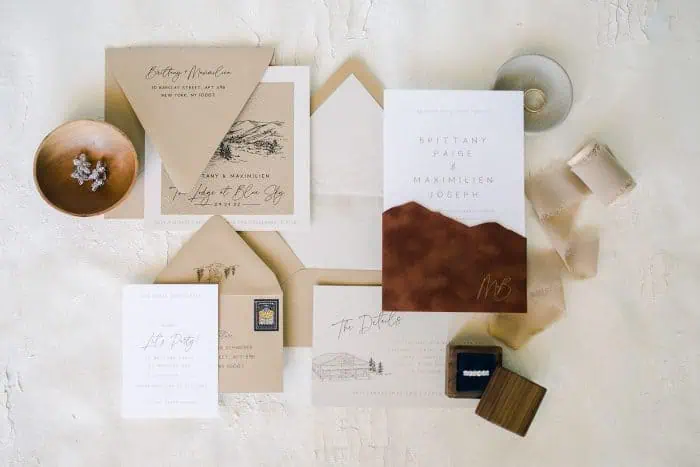 Wedding invitation suite with envelopes, RSVP cards, and decorative elements.