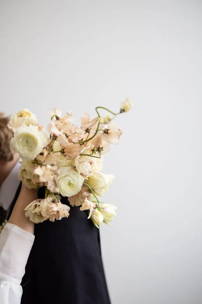 Elegant wedding bouquet featuring pastel roses and ranunculus, captured in a minimalist style for ro.