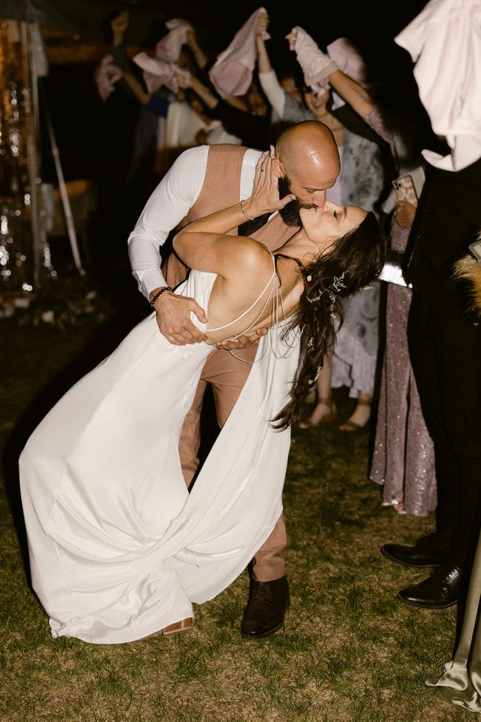 Romantic wedding dance featuring a bride and groom in a joyful embrace during celebration.