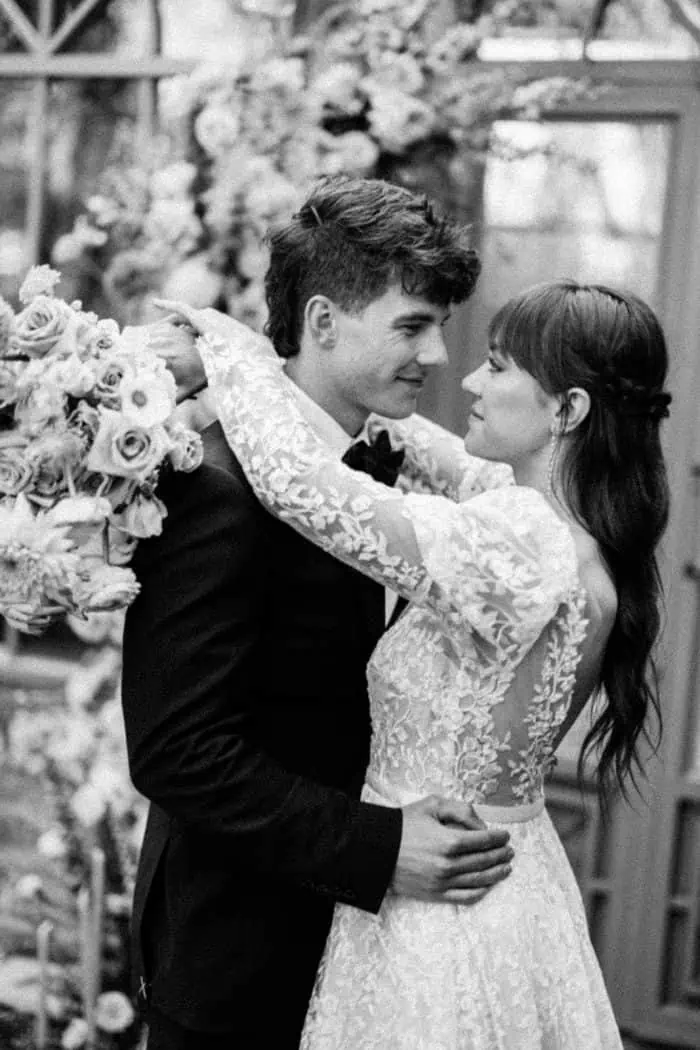 Elegant wedding couple embracing in a romantic black-and-white photograph.