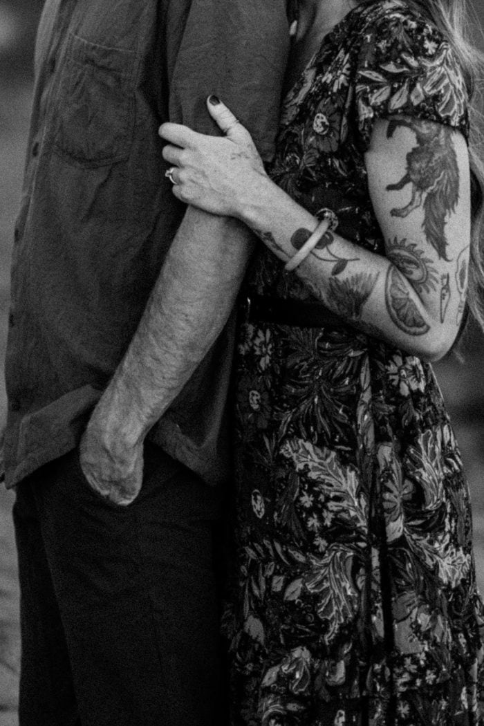 Close-up of a couple embracing, highlighting tattoos and emotional connection.