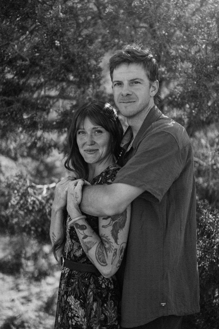 Portrait of a couple embracing outdoors in a natural setting.