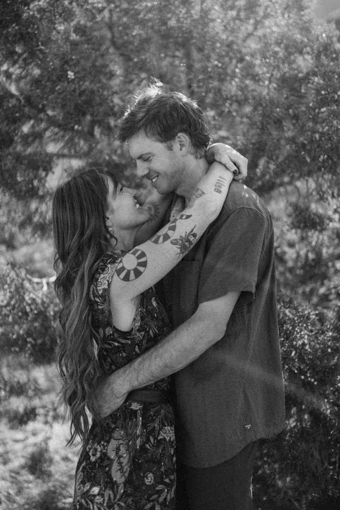 Romantic couple embracing outdoors, black and white photography.
