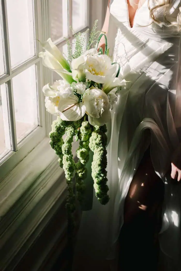 Elegant white floral bouquet with calla lilies and greenery.