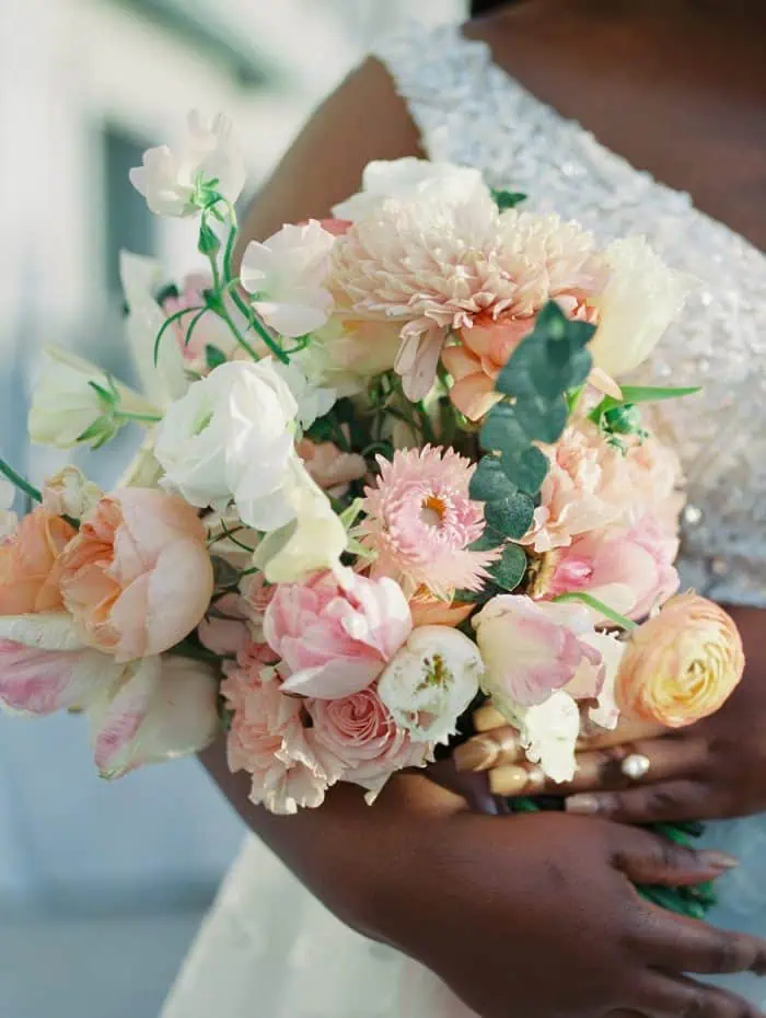 Bridal bouquet featuring pastel pink, white, and peach flowers, perfect for wedding photography.