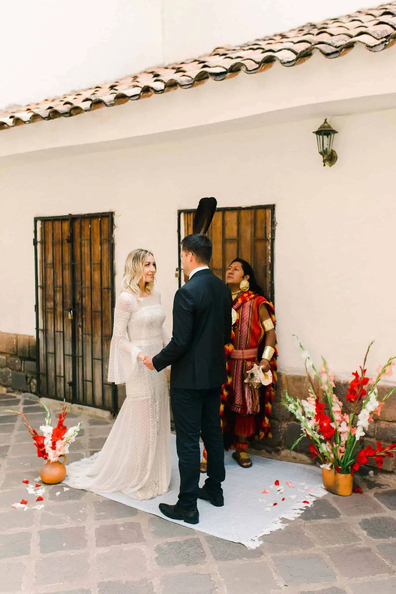 Cusco Peru Destination Wedding, travel wedding photography, Plaza de Armas ceremony with shaman, red flowers boho wedding