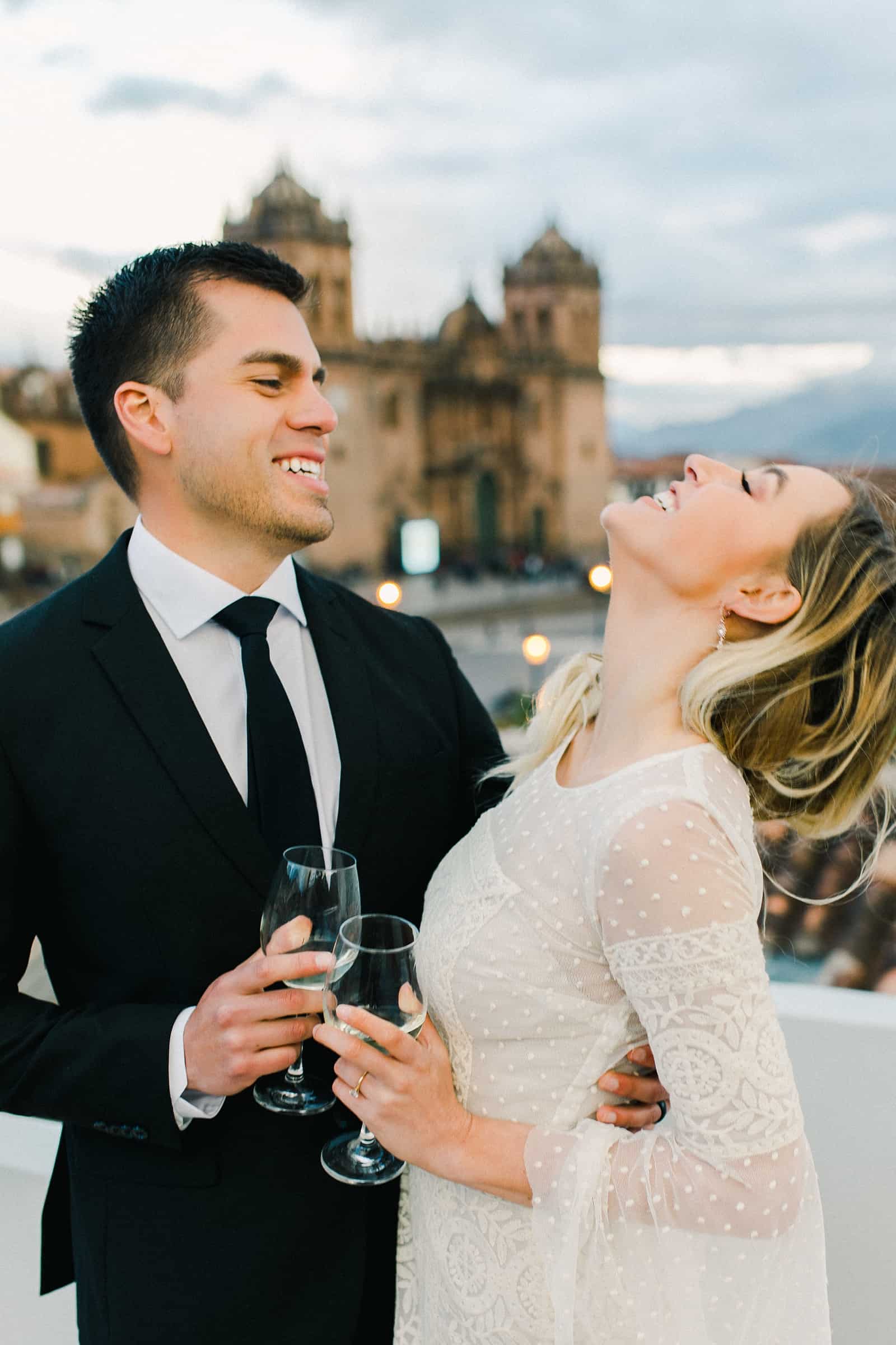 Cusco Peru Destination Wedding Inspiration, travel photography, bride and groom wedding dinner overlooking Cusco Cathedral , champagne toast