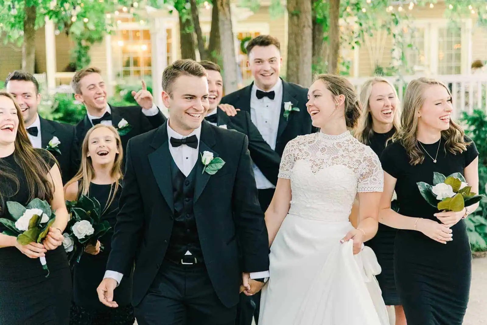 Clarion Gardens Utah Wedding, bride and groom laughing with bridal party, classic black tux with bow tie