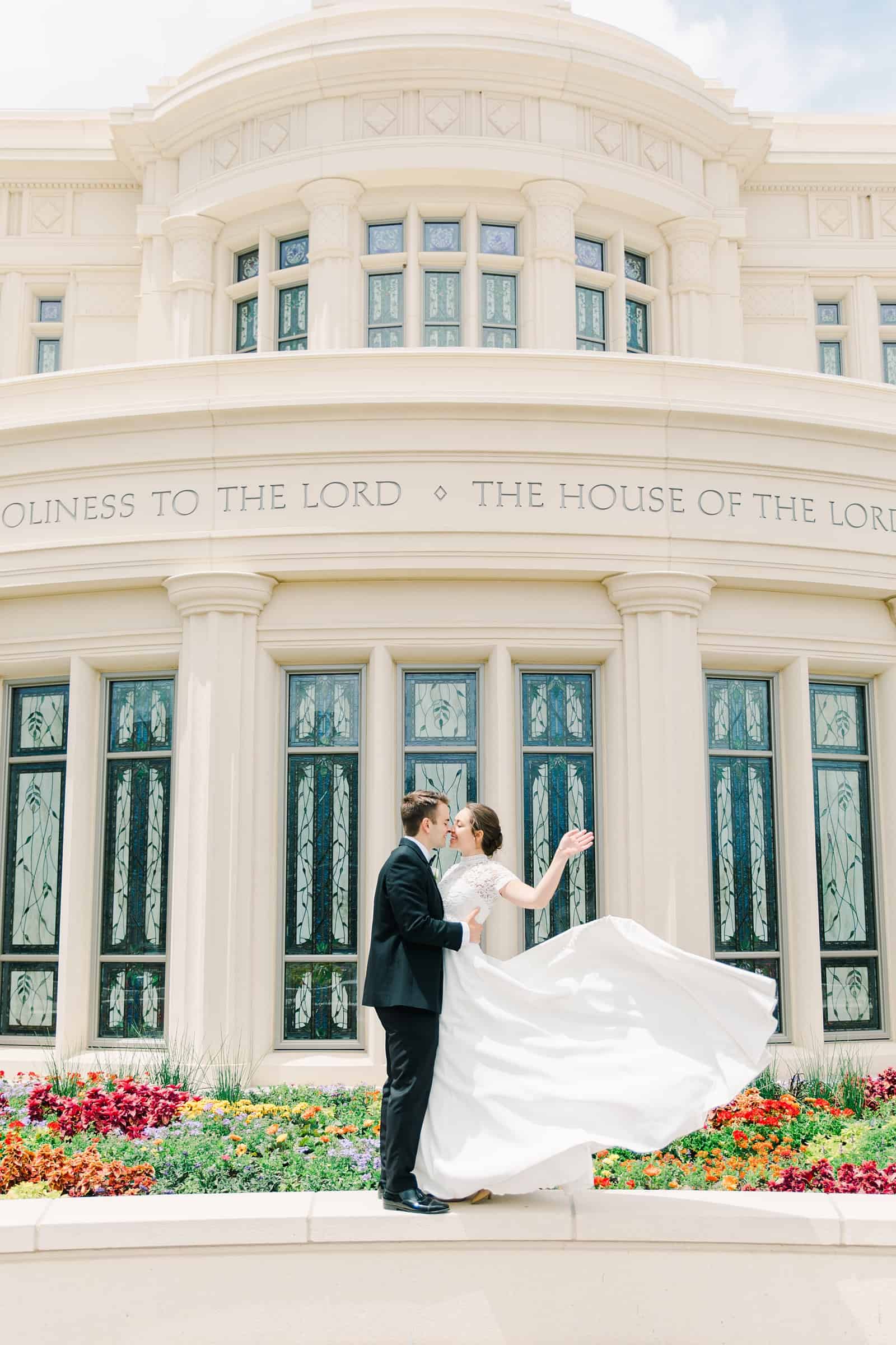 Payson Utah Temple wedding, bride and groom kiss near flower garden