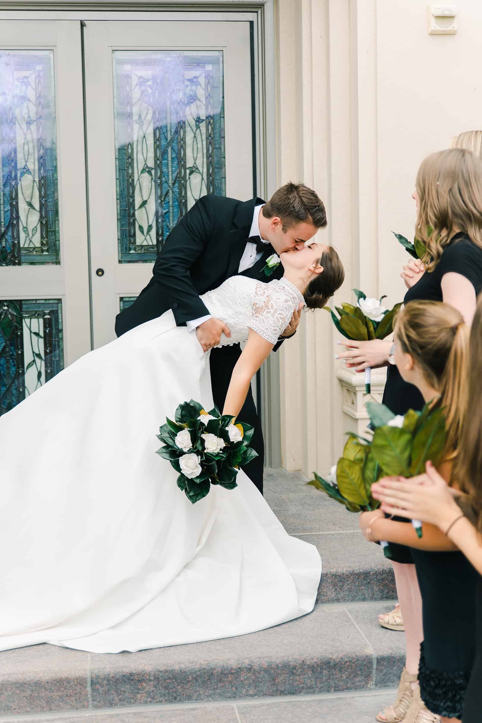 Payson Utah Temple wedding, bride and groom exit and dip kiss