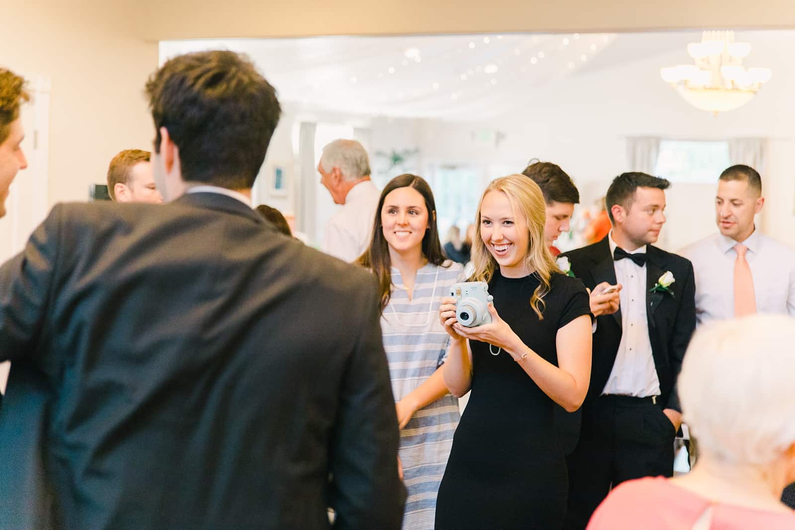 Clarion Gardens Payson Utah Wedding, bridesmaid takes picture with Fuji Instax camera polaroid camera