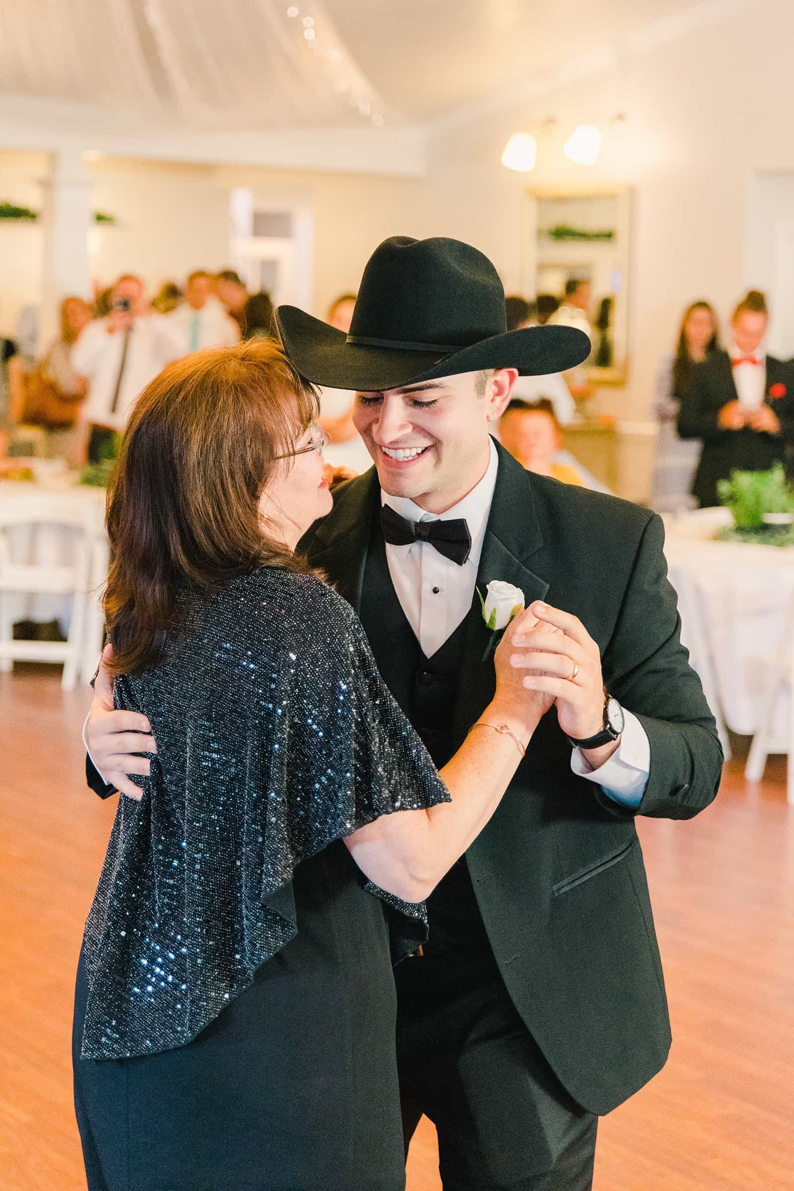 Clarion Gardens Payson Utah Wedding, groom wears cowboy hat and dances with mother of the groom