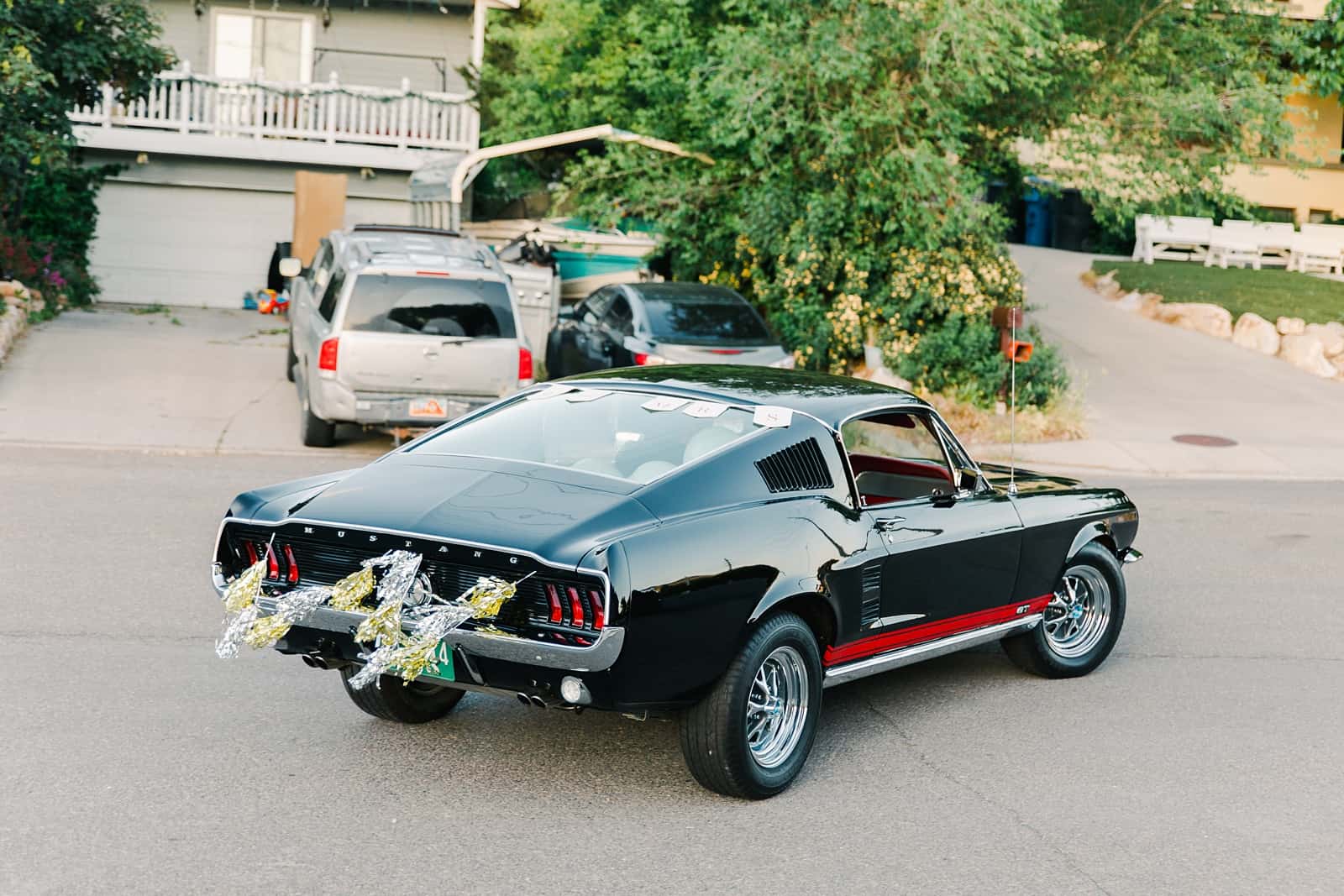 Clarion Gardens Payson Utah Wedding, bride and groom drive away in black vintage Mustang convertible reception getaway car