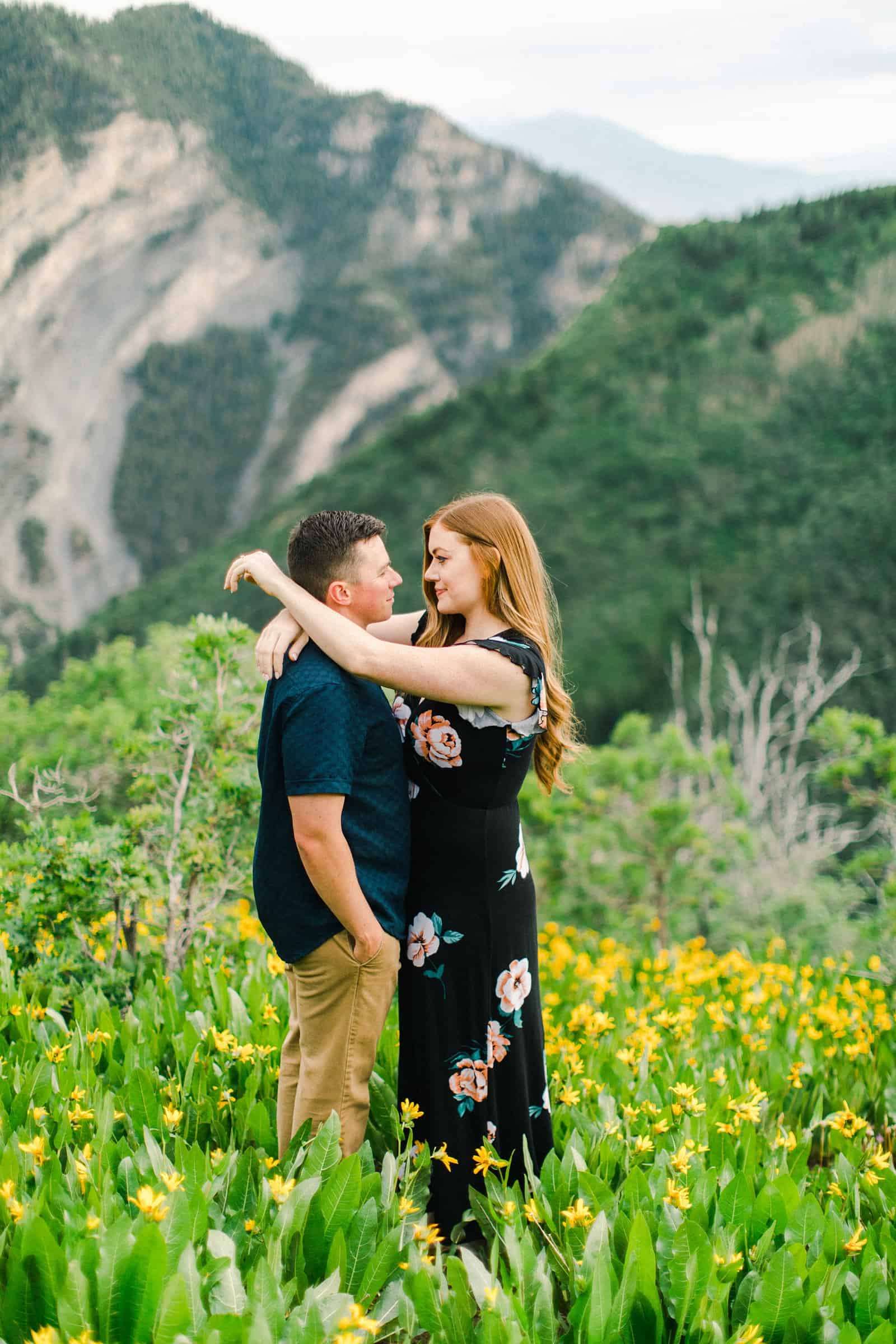 Provo Canyon wildflowers field engagement session, Utah wedding photography, engaged couple kissing in yellow flowers and mountains