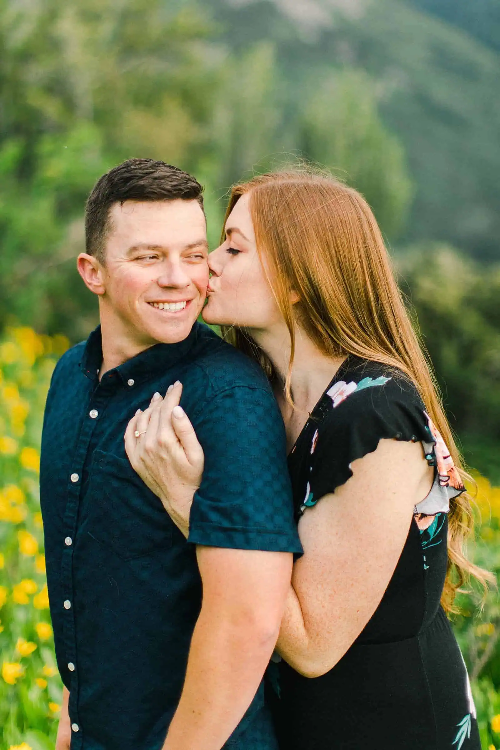 Provo Canyon wildflowers field engagement session, Utah wedding photography, engaged couple kissing in yellow flowers and mountains