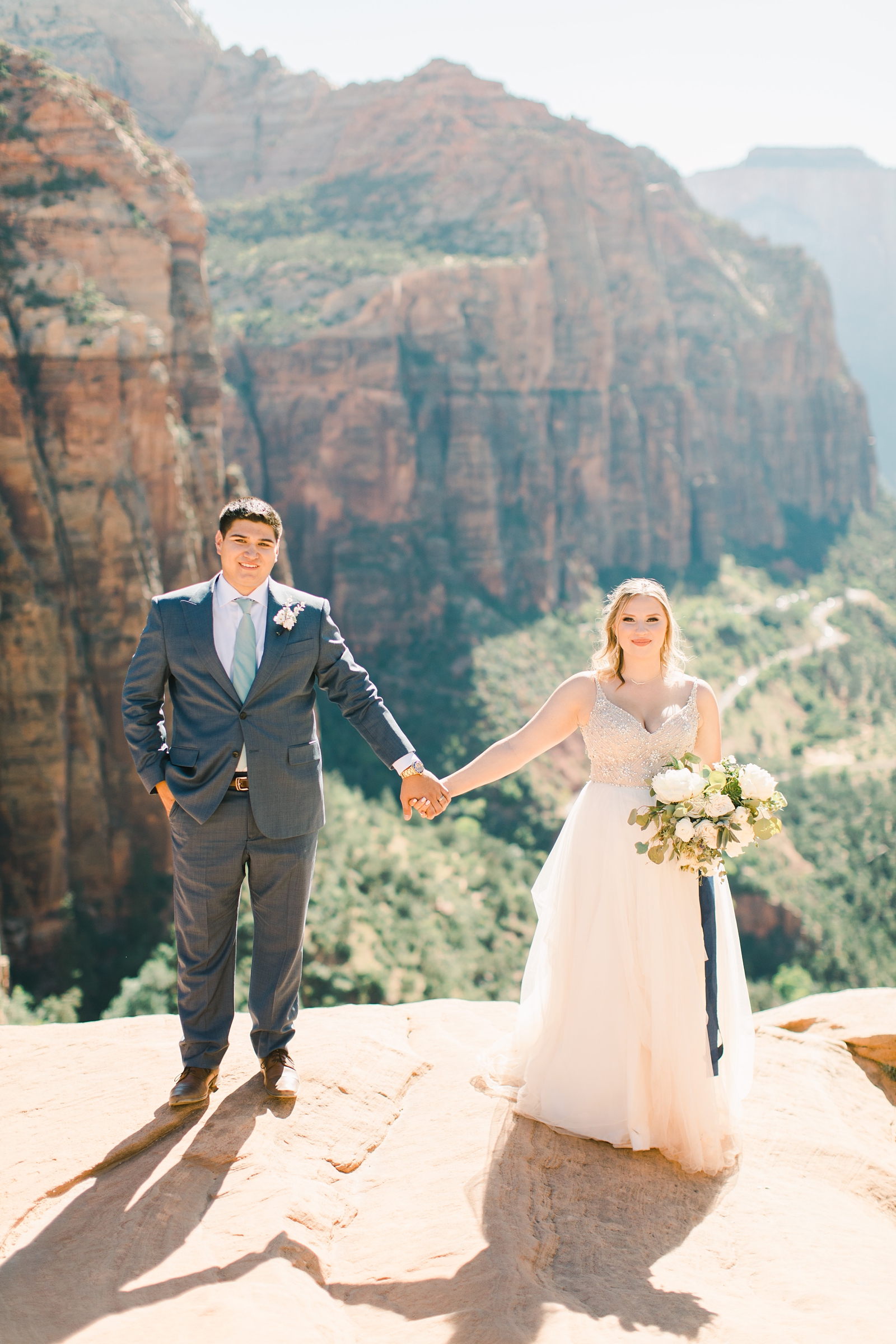 Bride and groom holding hands overlooking Zion National Park