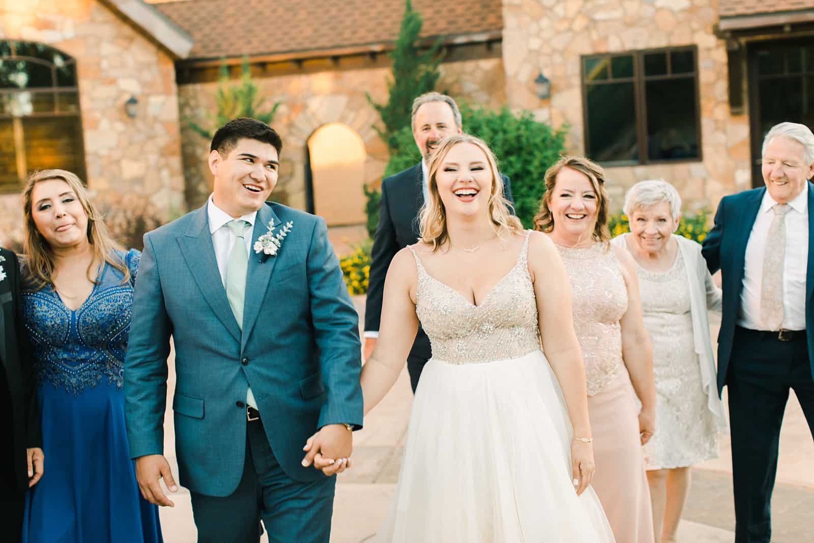 Bride and groom laughing with family