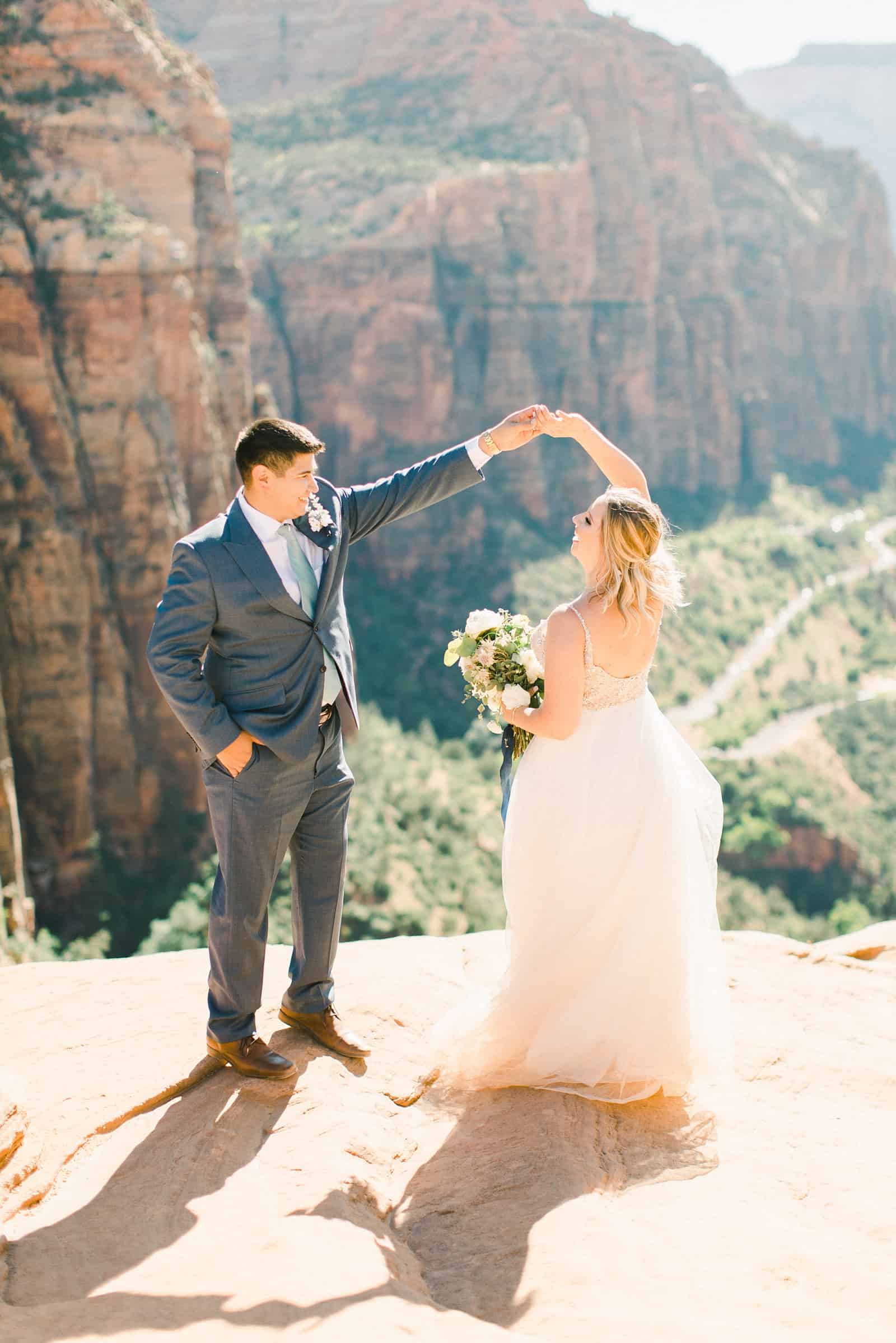 bride and groom dancing near cliff in in Zion National Park