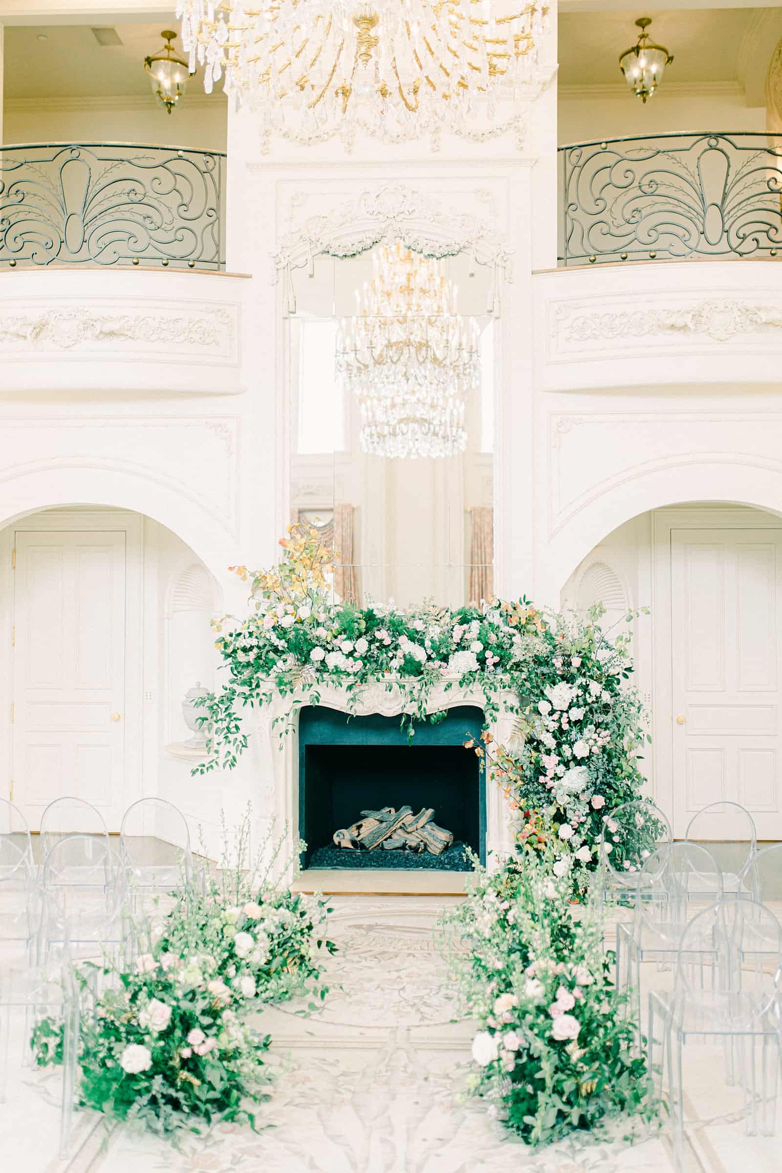 Ceremony backdrop garland with greenery and flowers in front of fireplace