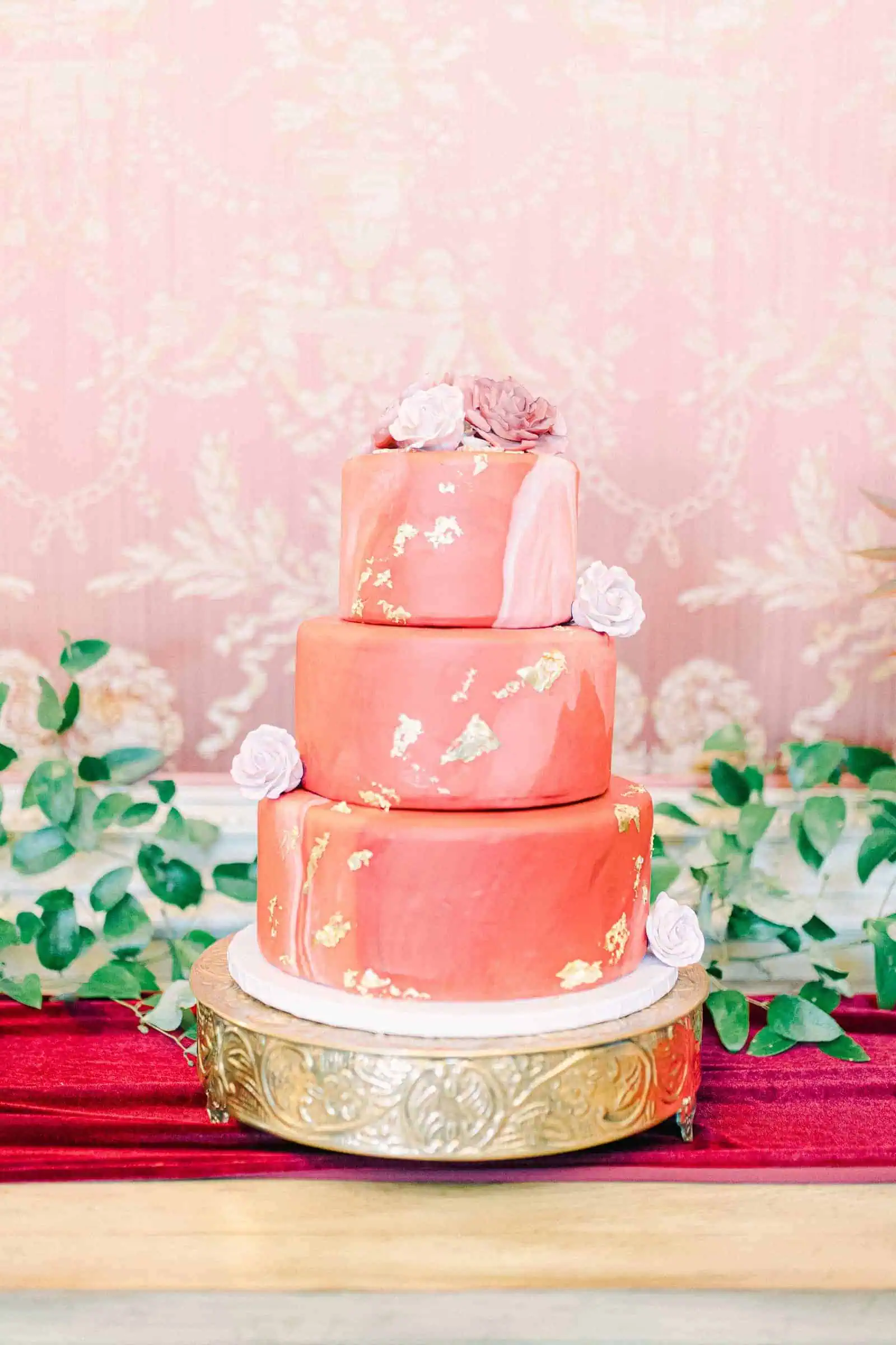 Elegant wedding cake with pink red and gold leaf