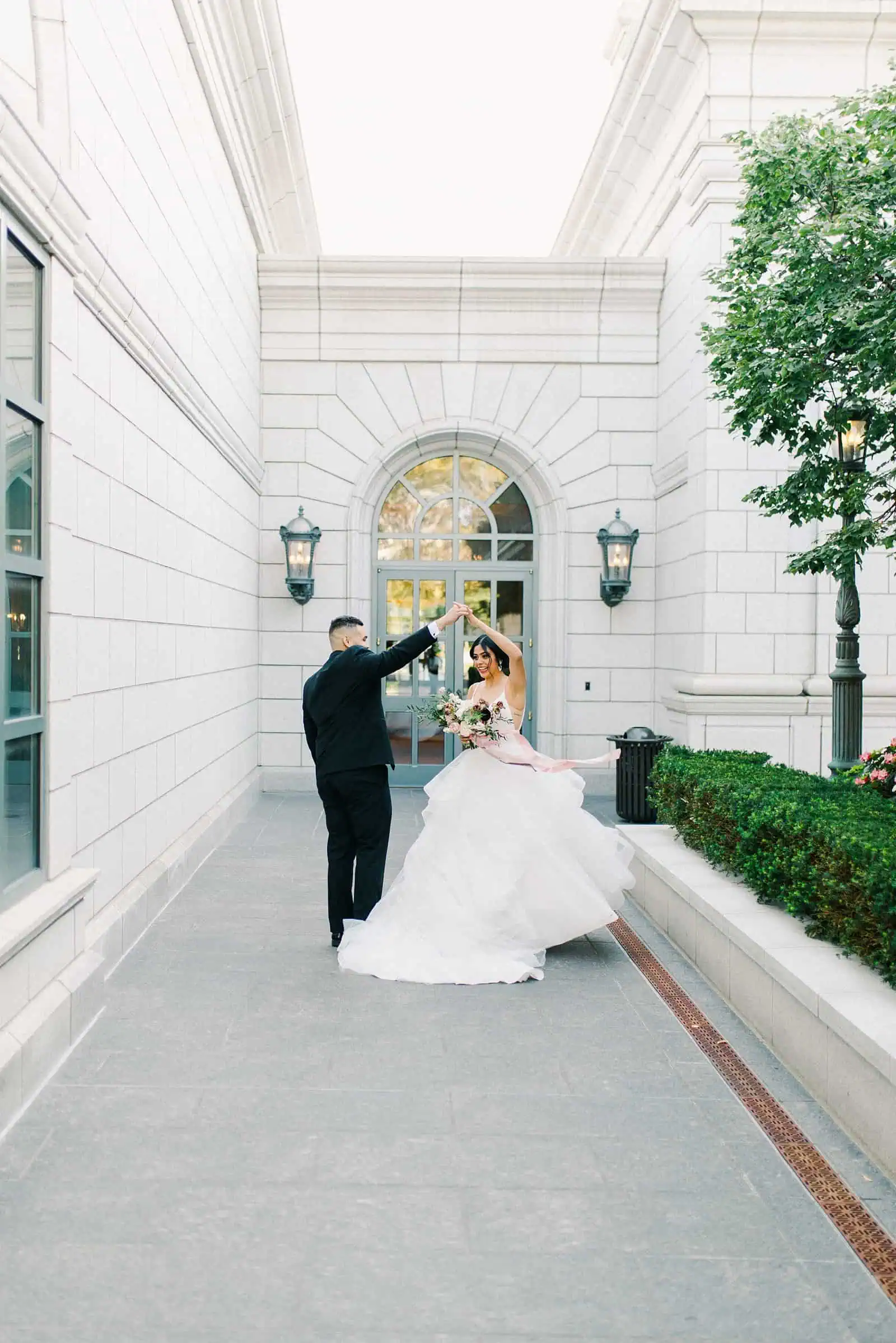 Bride and groom dancing together in the courtyard of the Grand America hotel in Salt Lake City