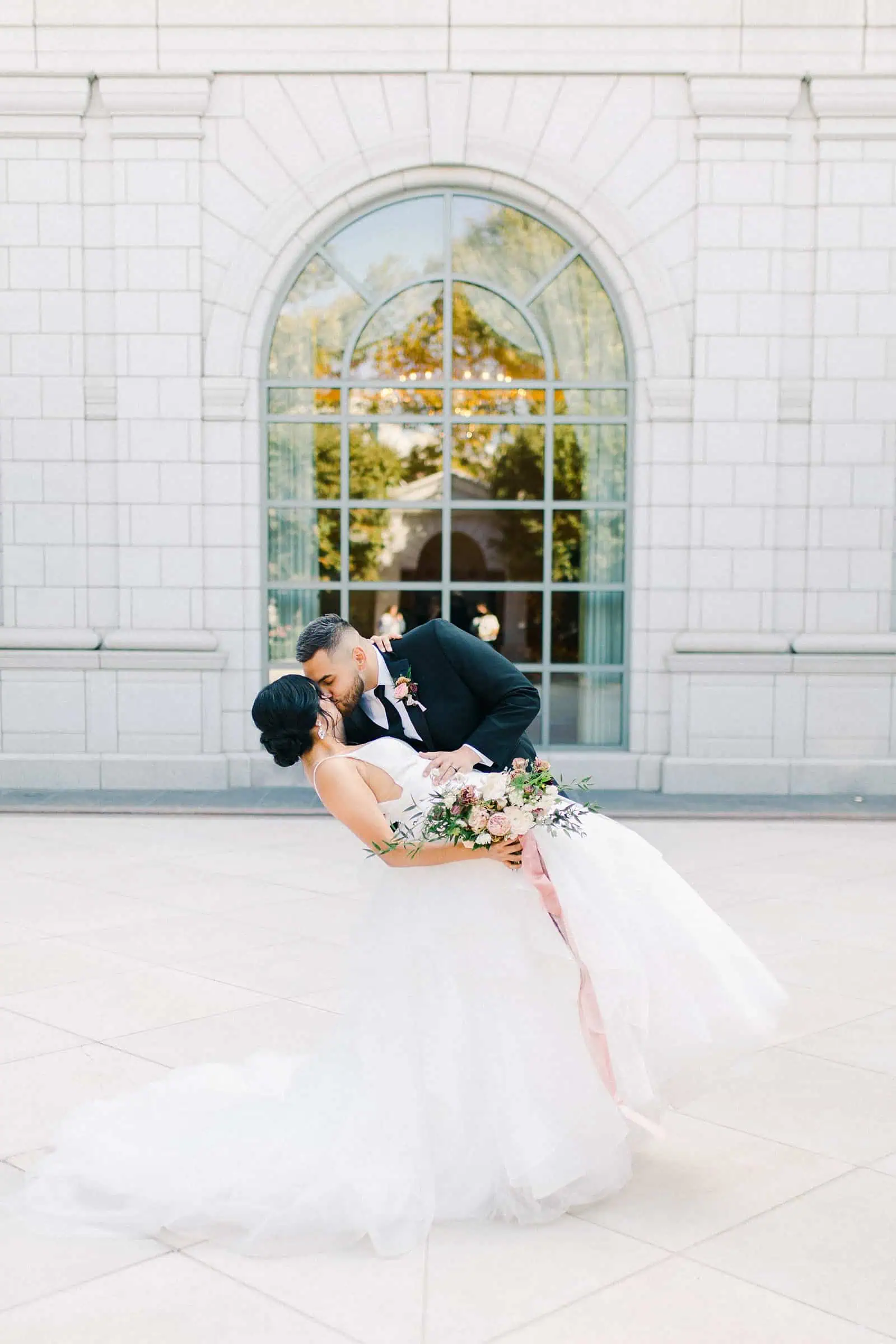 Bride and groom kiss and dip