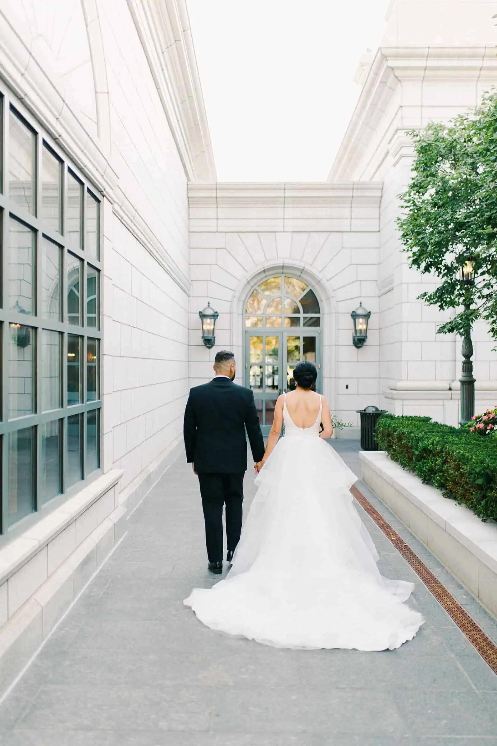 Groom and bride with long train walk together