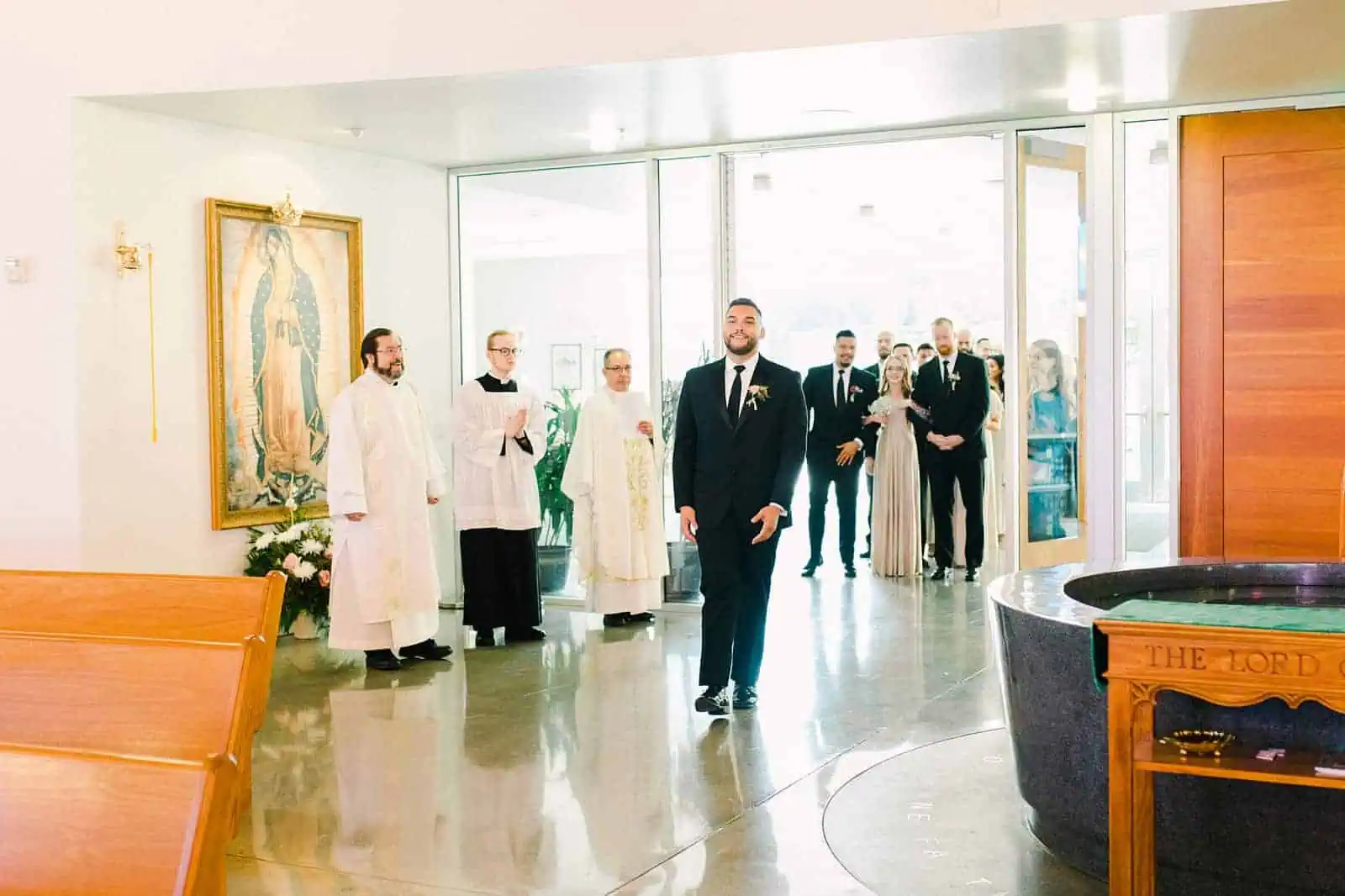 Groom walks down the aisle in traditional Catholic ceremony