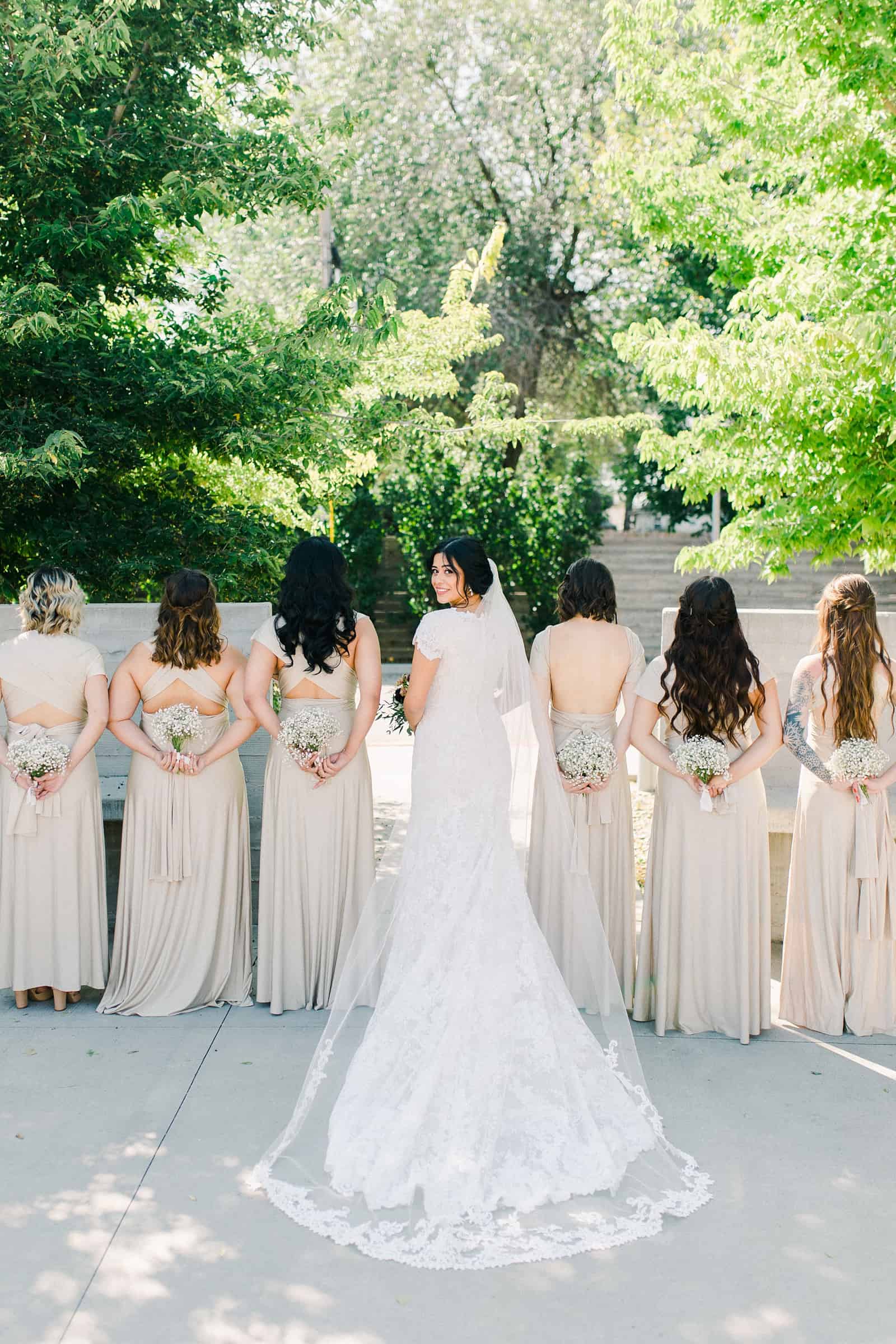 bride with long train and bridesmaids wearing gold champagne long maxi bridesmaids dresses with baby's breath bouquets,