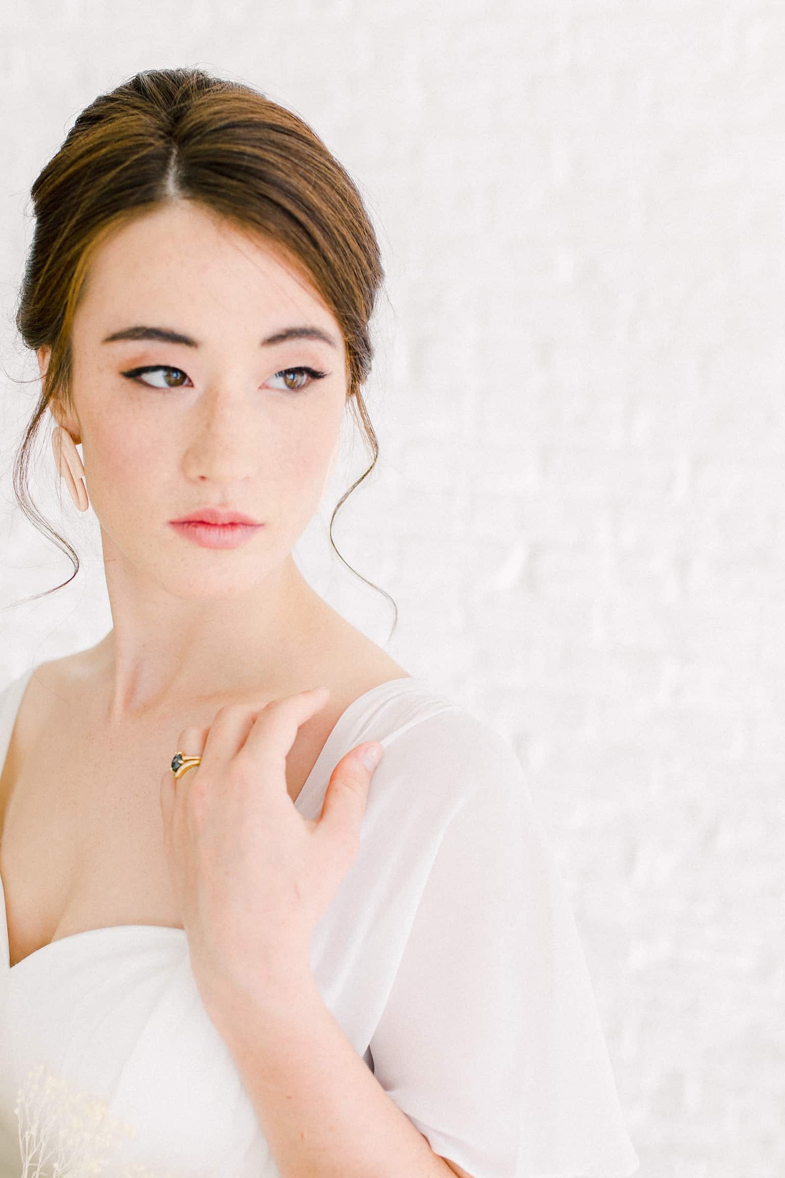 Modern bride with sleep updo, statement earrings and sweetheart neckline