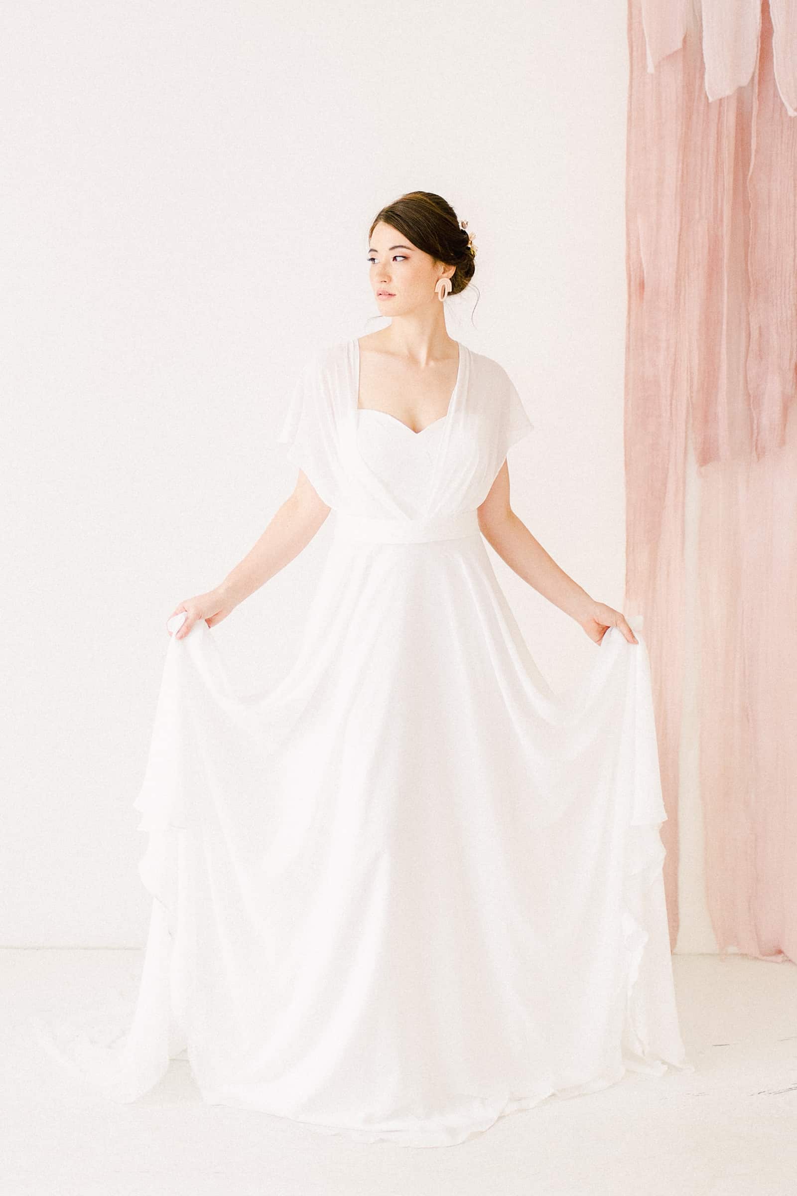 Bride wearing Simple modern chiffon flowy wedding dress with sweetheart neckline