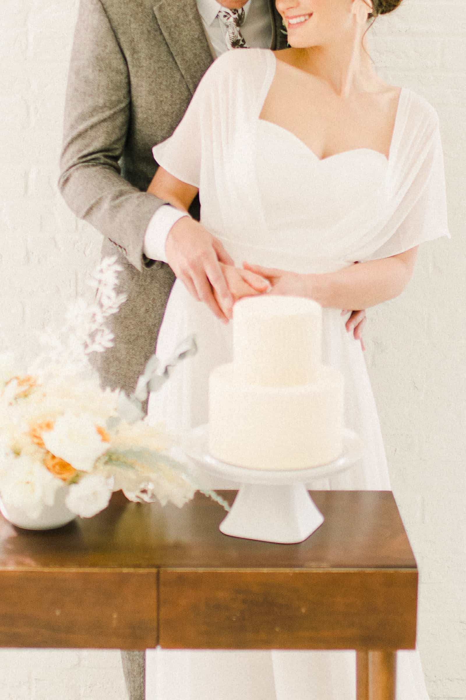 Bride and groom cut the cake, Modern minimalist white wedding cake with geometric design