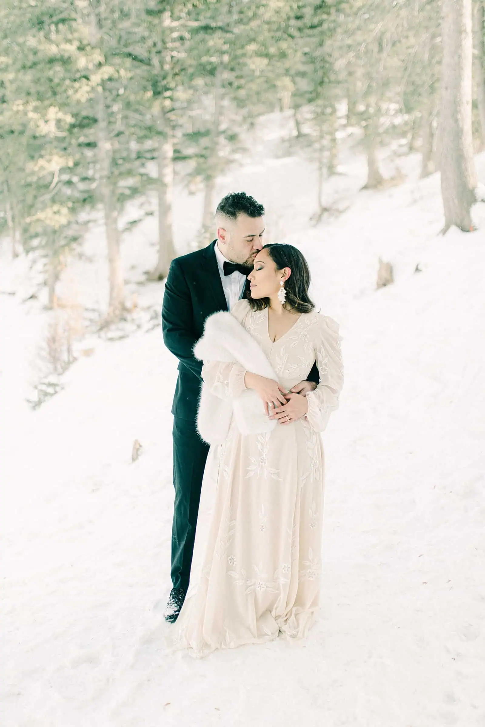 Bride and groom in snowy trees, winter wedding