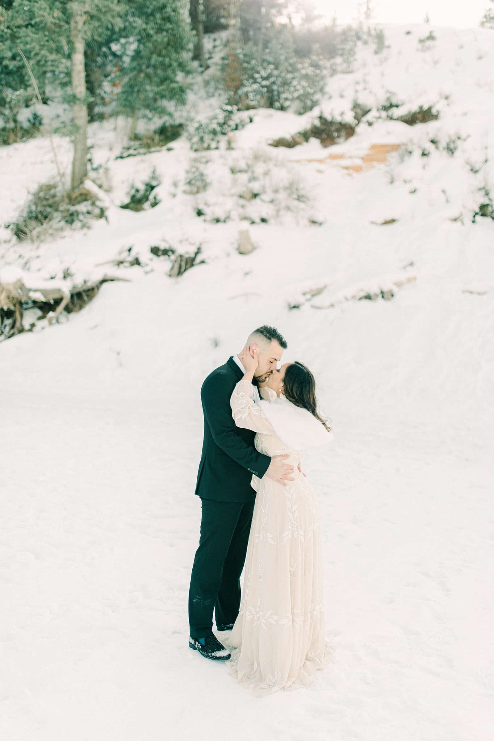 Bride and groom snowy winter mountains of Utah