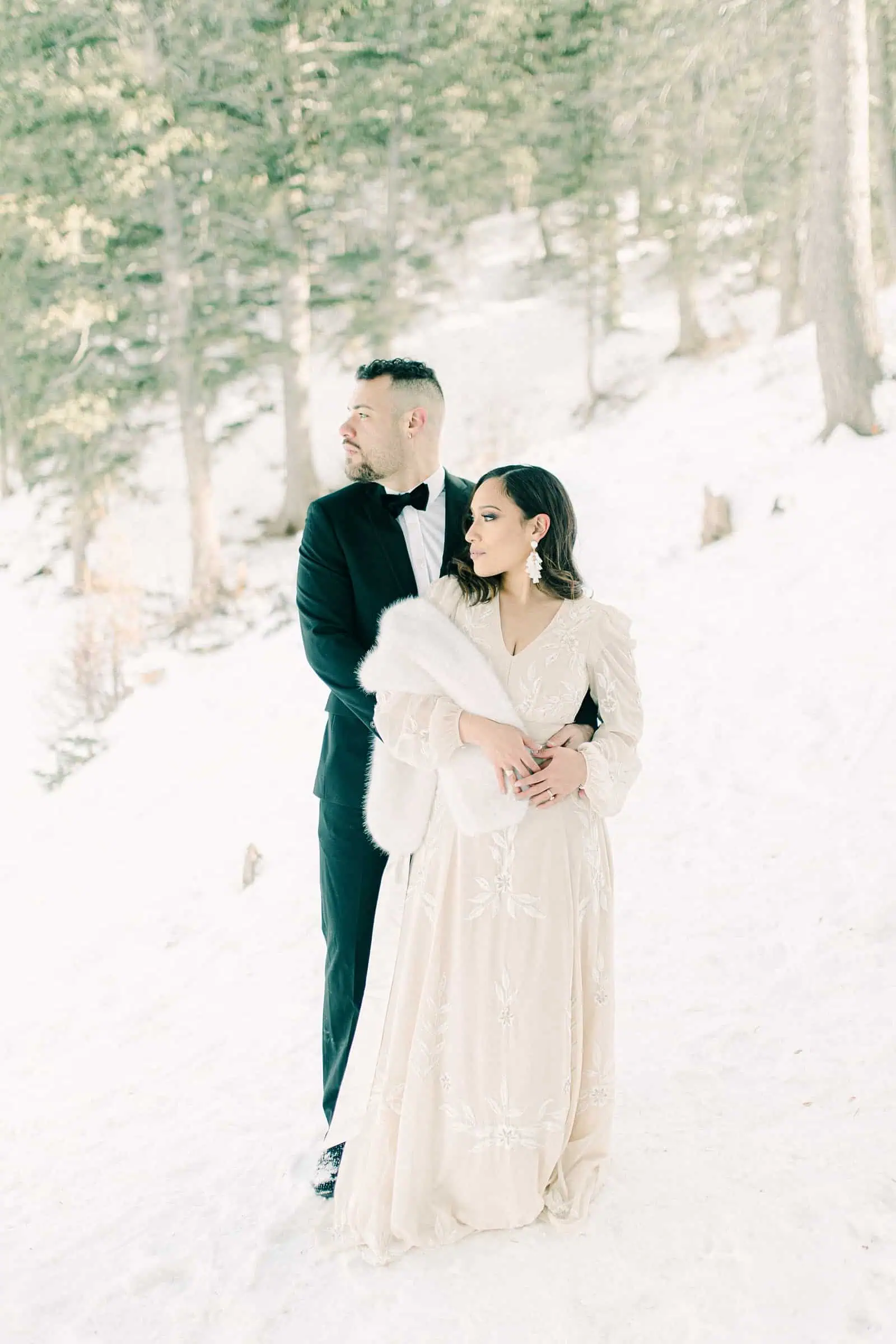 Bride and groom in snowy trees, winter wedding