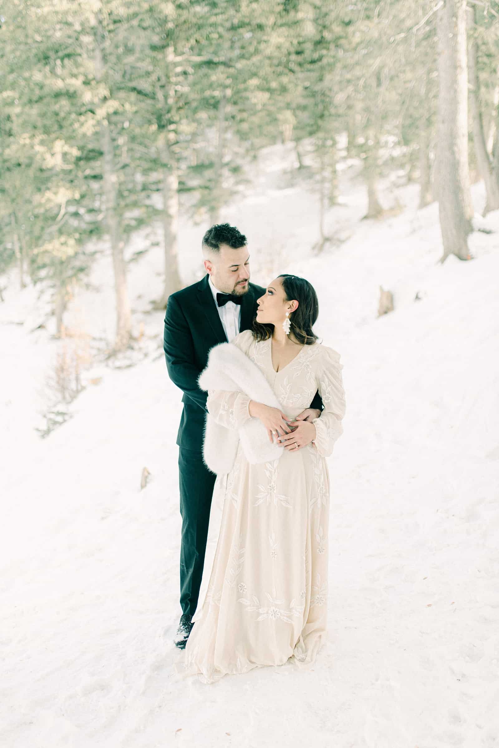Bride and groom in snowy trees, winter wedding
