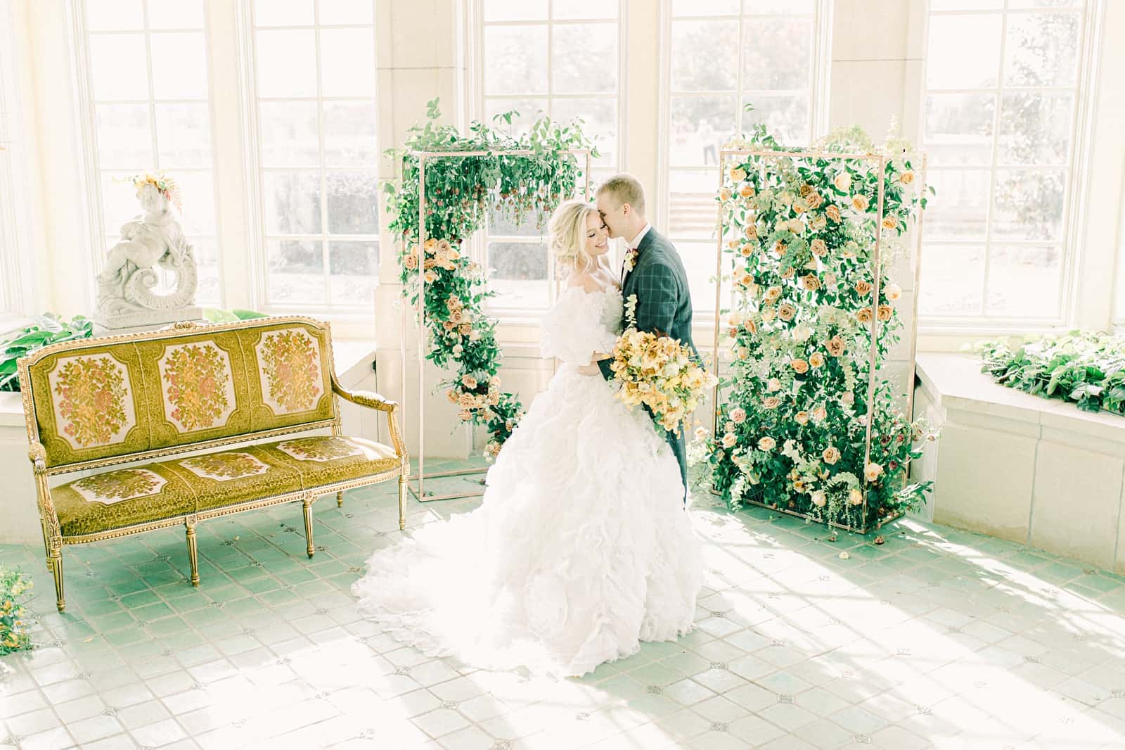 Bride and groom during wedding ceremony surrounded by flower backdrop, destination wedding photography