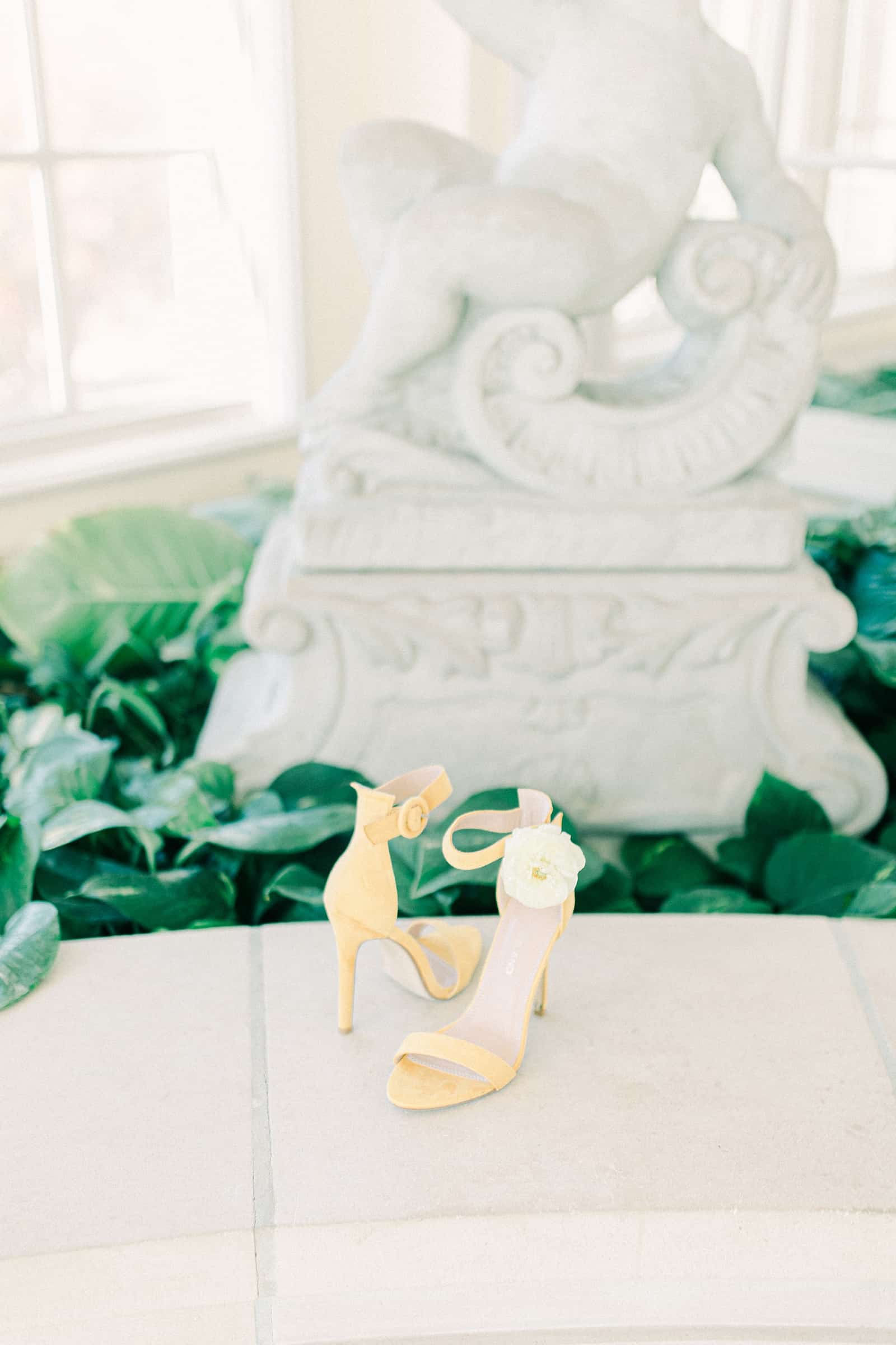 Bride wedding shoes with flowers in greenhouse wedding