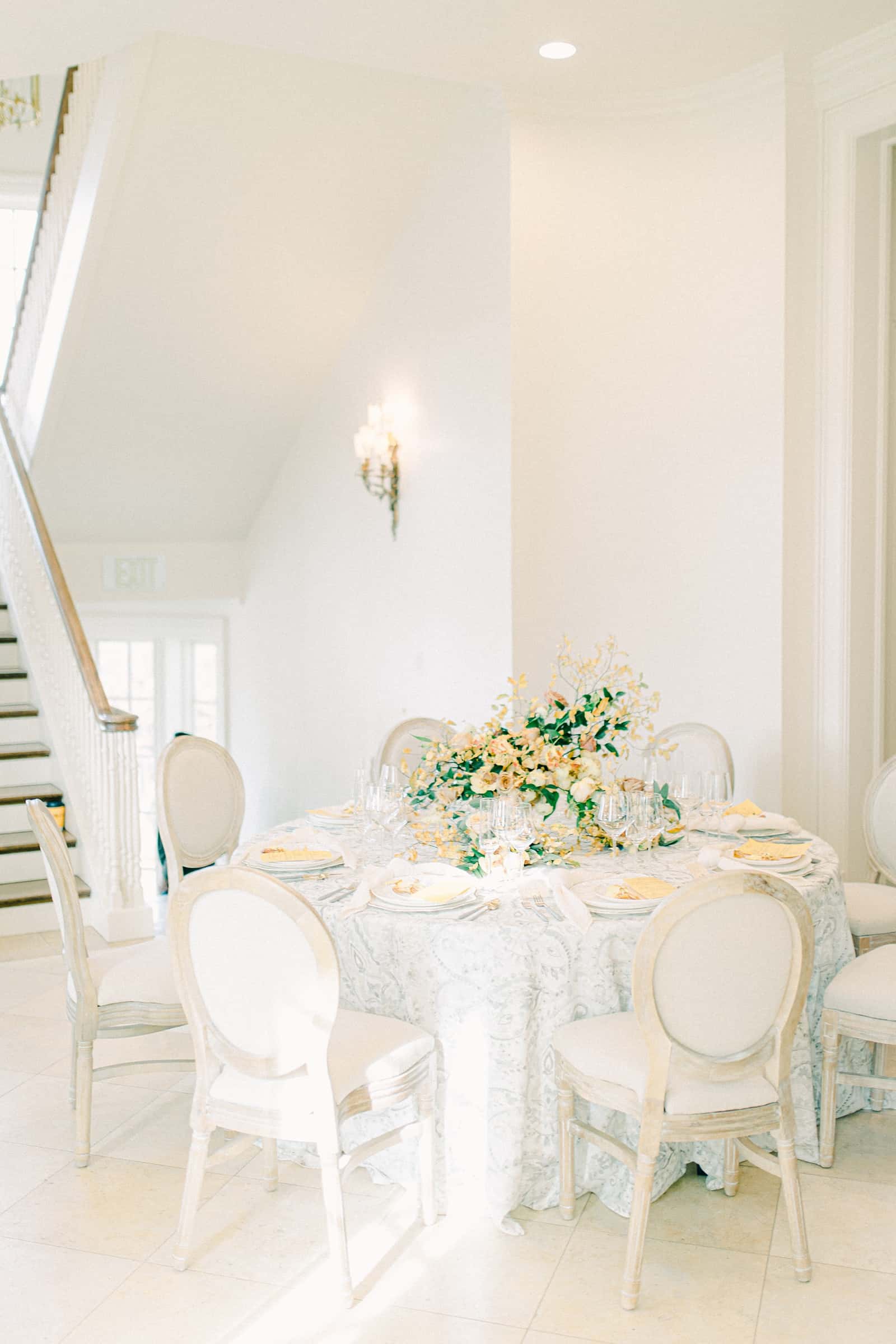 Fine Art wedding table setting with gray damask tablecloth and orange, white and green centerpiece