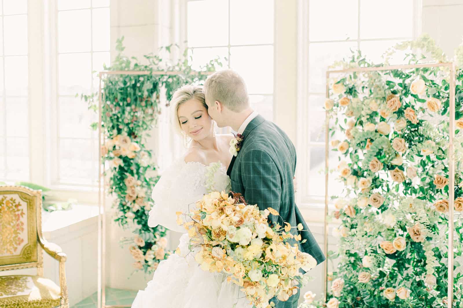 Bride and groom wedding ceremony with elaborate floral backdrop